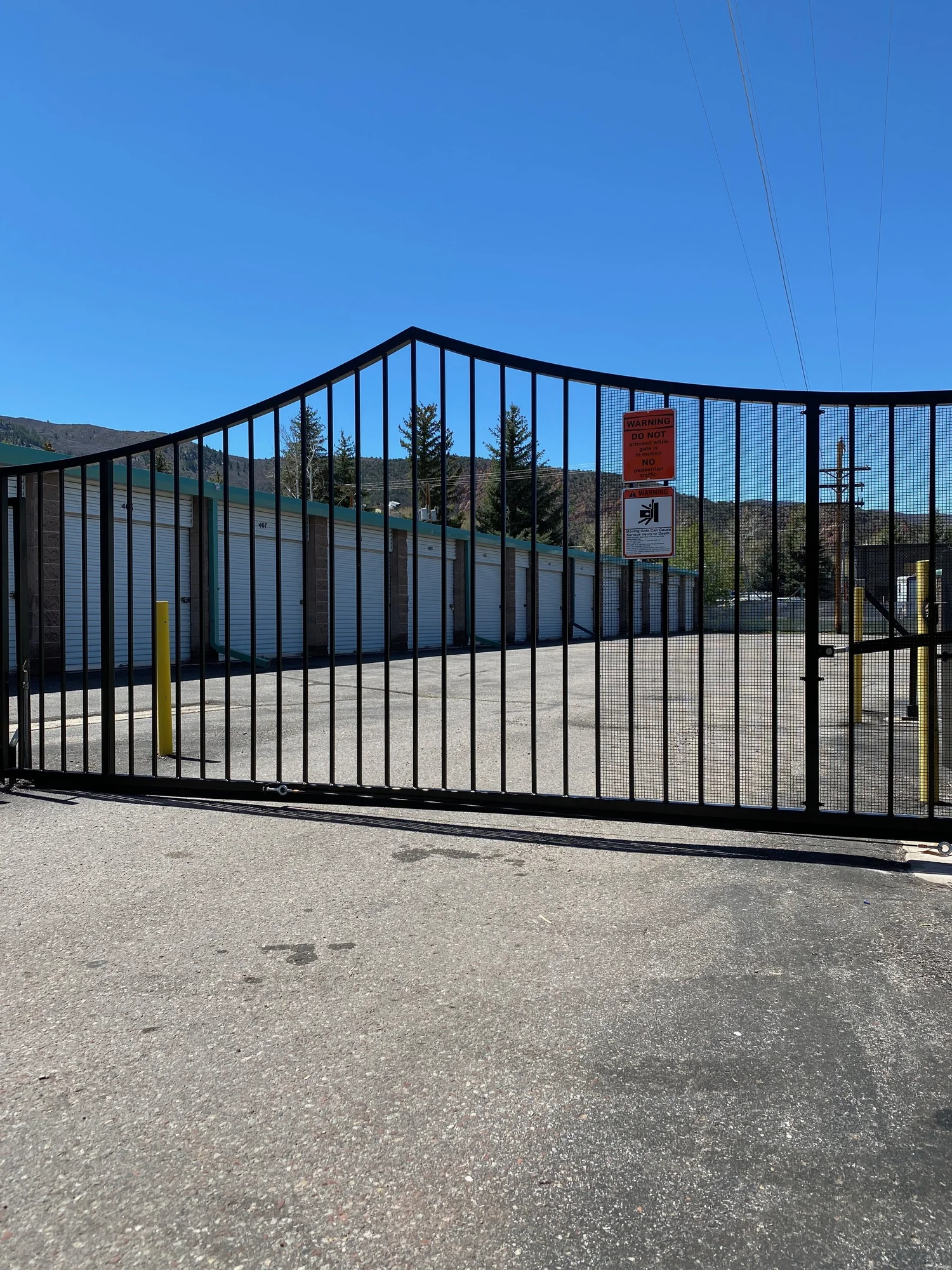 The closed security gate at All Hours Storage in Basalt, with storage units behind the fenced perimeter