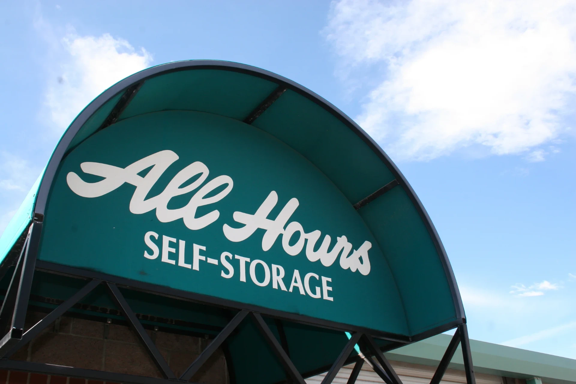 Green arched All Hours Self Storage awning over the office entrance on Park Ave in Basalt, Colorado